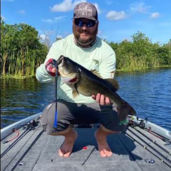 man holding a huge bass caught on 16" snake lure for big bass