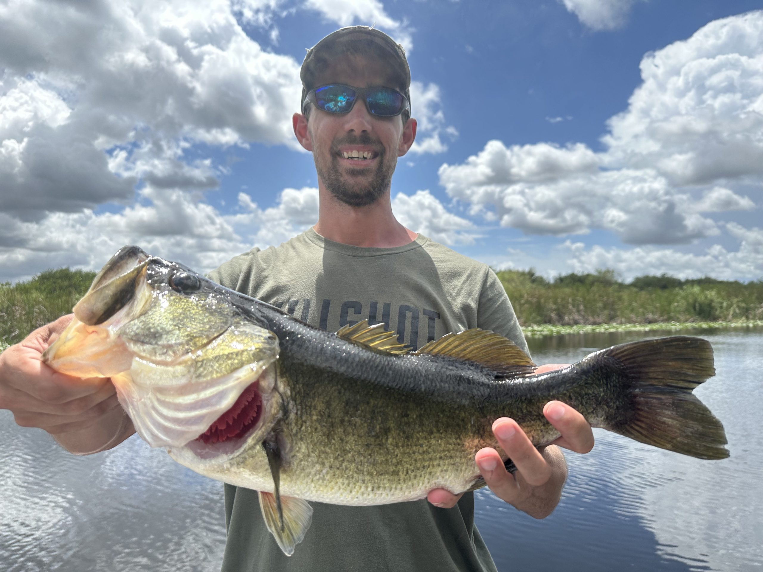 Texas bass angler holding a large largemouth bass on the water during a successful fishing trip